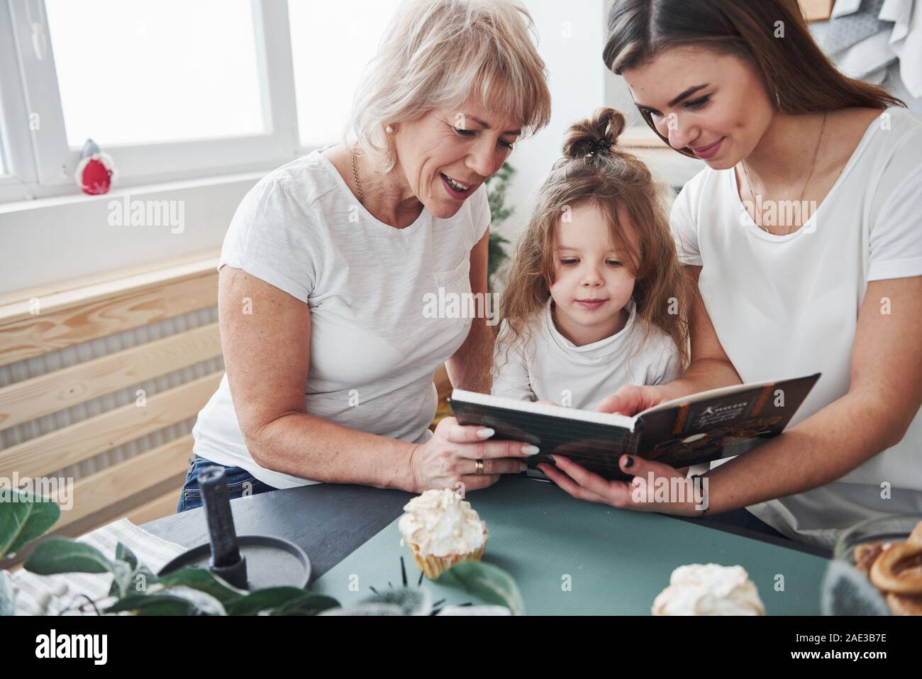 Fast learning kid. Mother, grandmother and daughter having good time in the kitchen Stock Photo