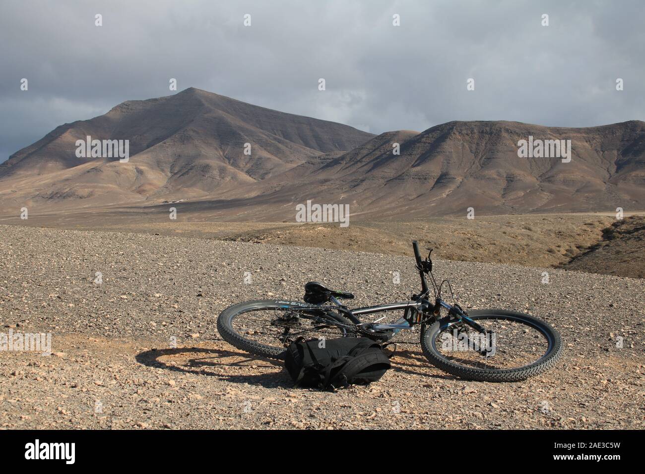 mountain bike laying on the floor with volcanic mountains in the background Stock Photo