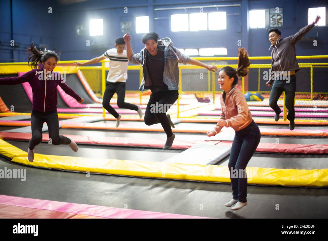 Happy young friends jumping on trampoline Stock Photo Alamy
