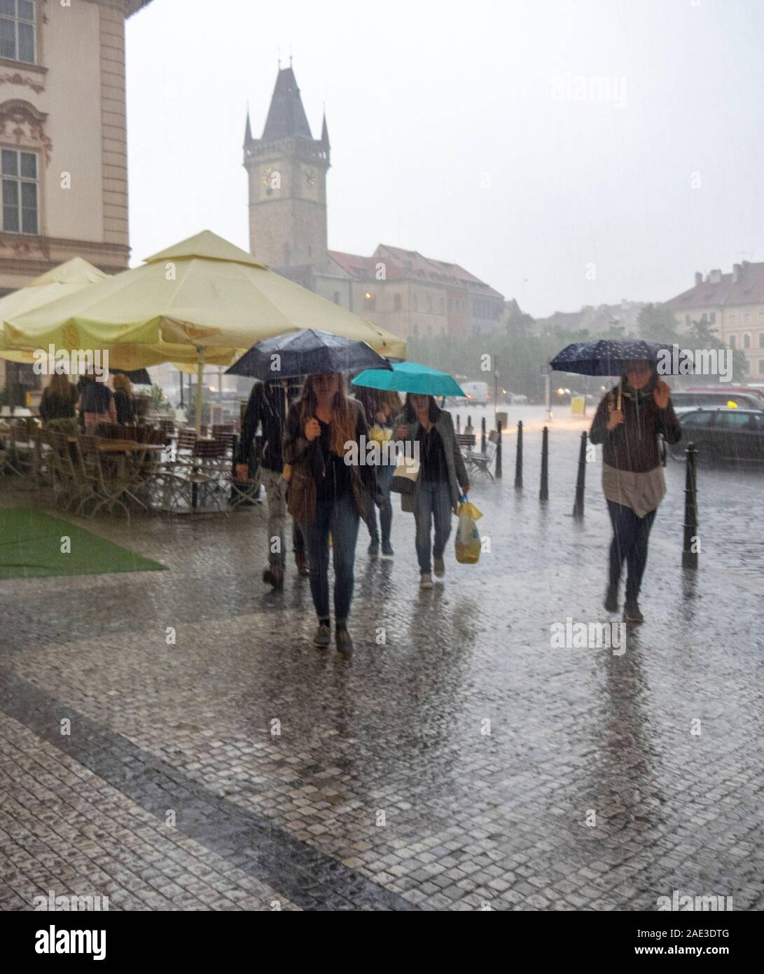 Tourists with umbrellas in a heavy rain fall in Old Town Square Prague Czech Republic. Stock Photo