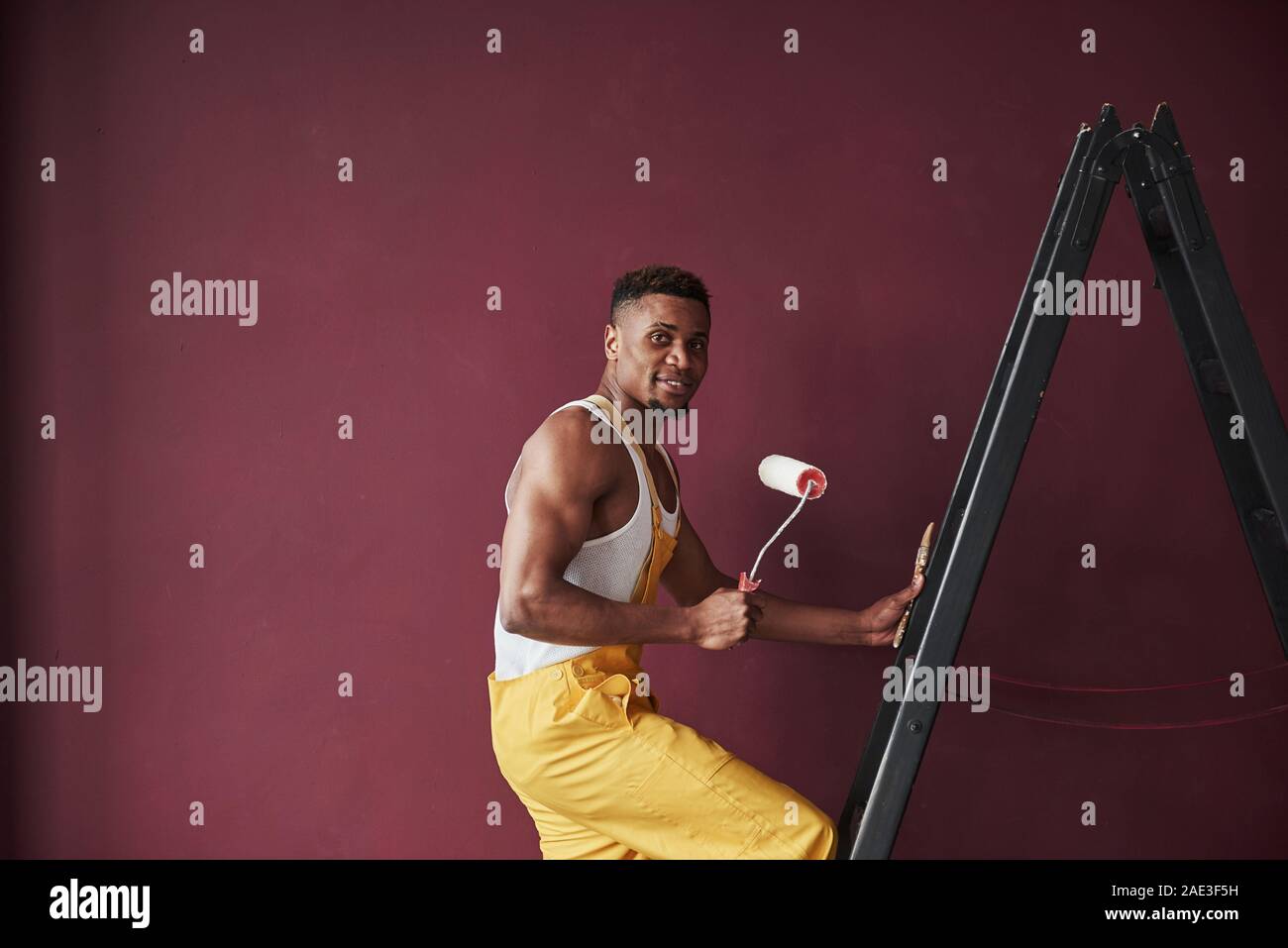 Young african american worker in the yellow uniform have some job Stock Photo