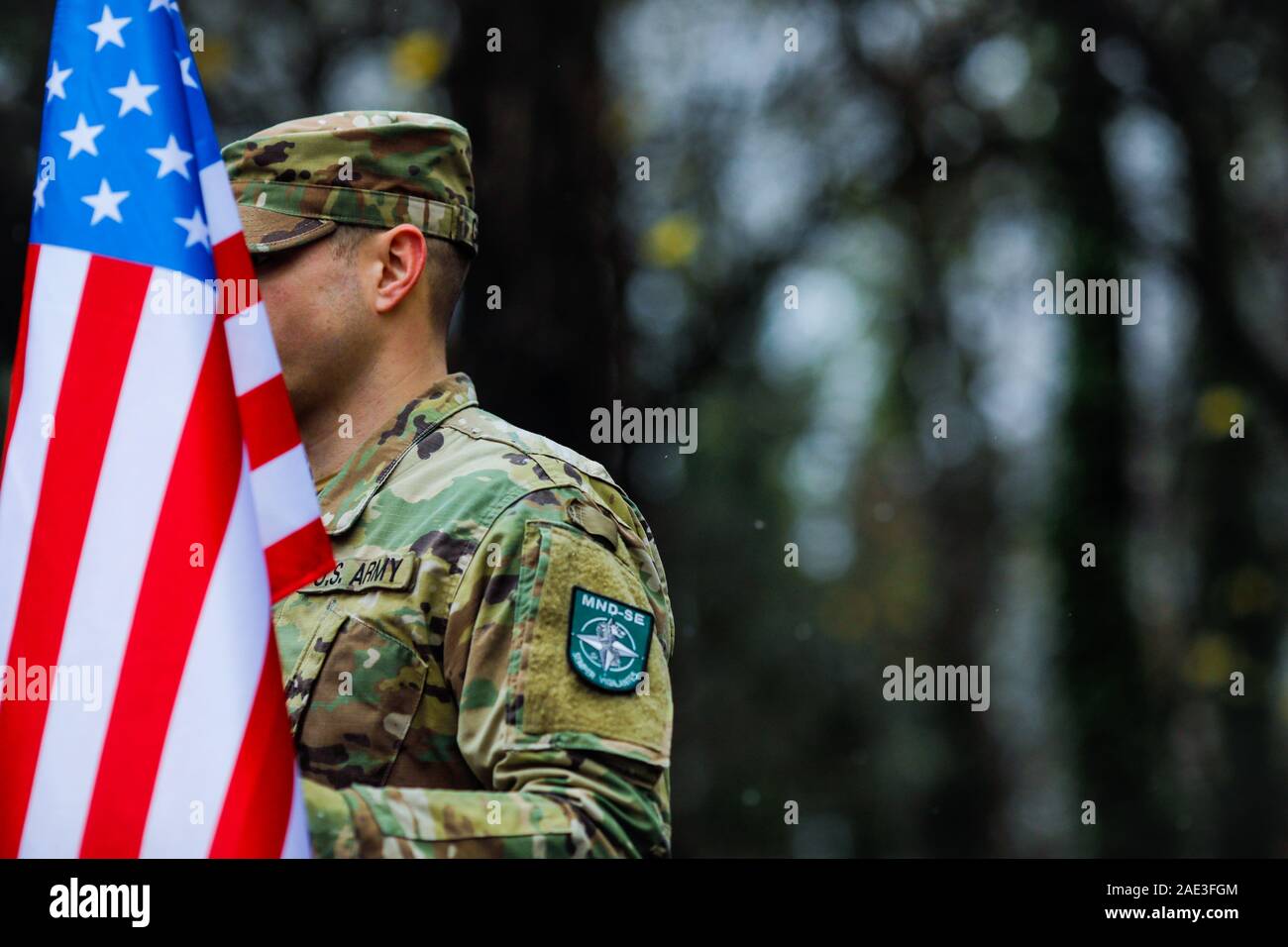 Bucharest, Romania - December 1, 2019: Shallow depth of field image (selective focus) with details of a US army soldier holding a flag and having MNDS Stock Photo