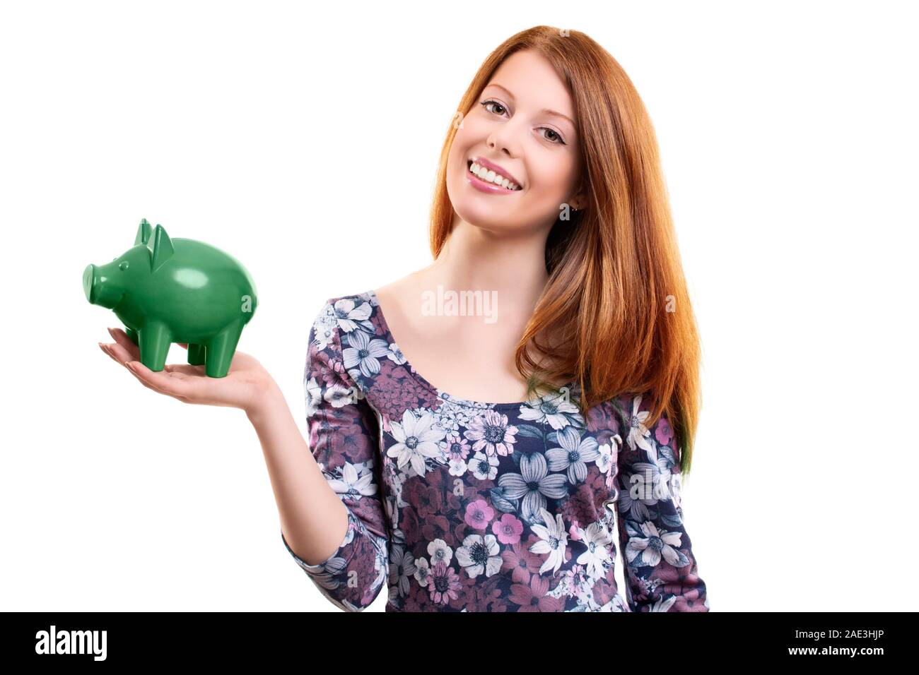 Portrait of a beautiful young woman holding a green piggy bank in her ...