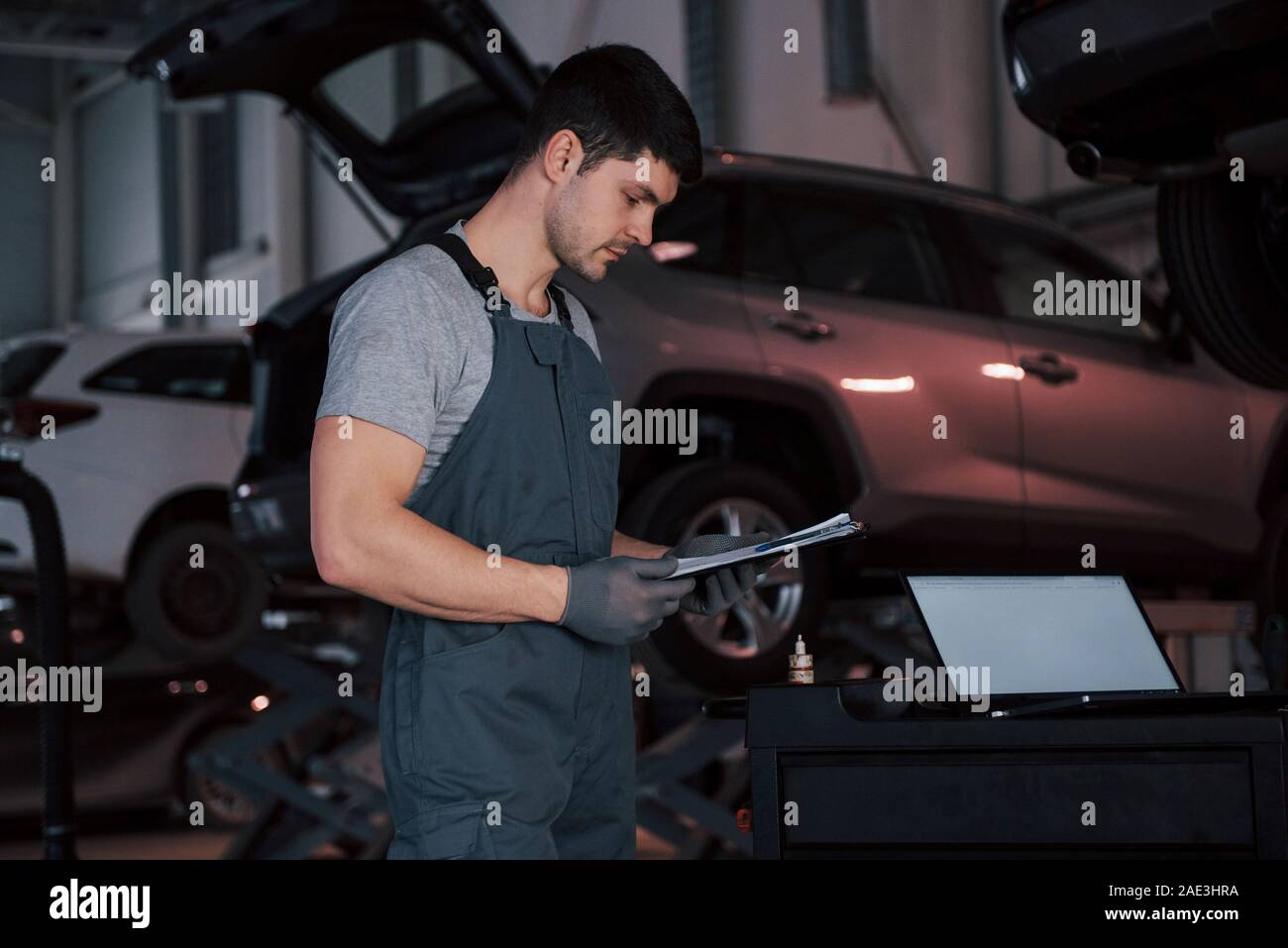 Worker stands indoors in uniform does reports, calculations and looking at the plans Stock Photo