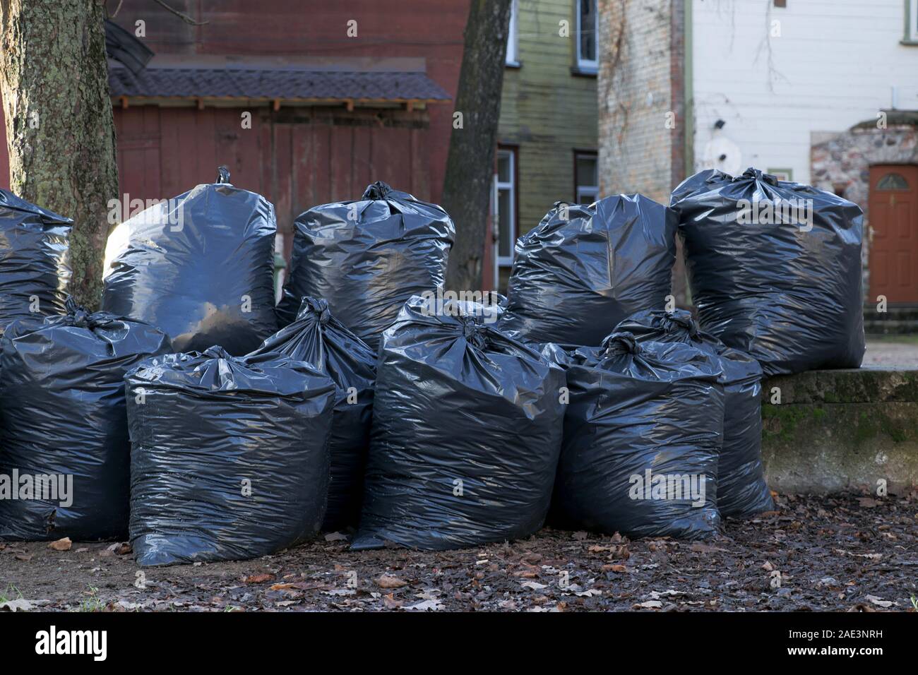 Big pile of black plastic garbage bags with trash stacked on the