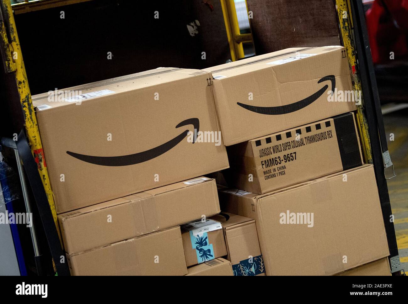 05 December 2019, Brandenburg, Börnicke: Parcels with the Amazon online  mail order company logo are lying on a tug in the DHL parcel centre. During  Advent, up to 570,000 shipments a day