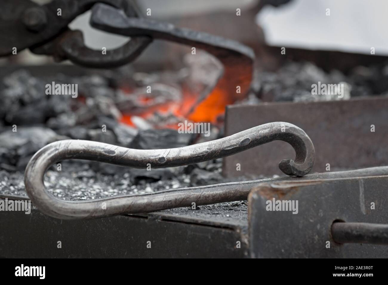 Horseshoe heating for A blacksmith holds hot horseshoe with large tongs above