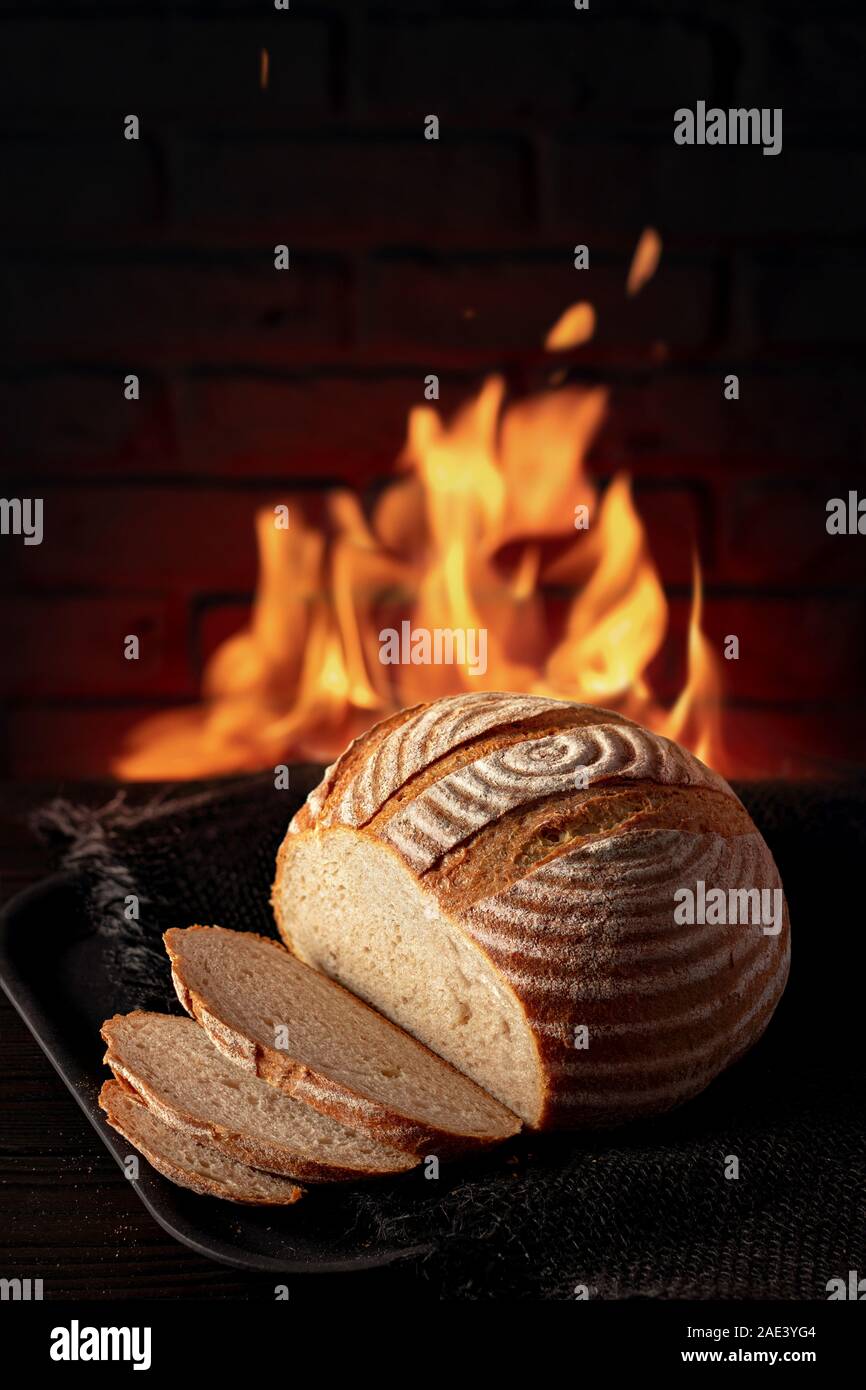 Traditional house bread on the table in front of a brick oven Stock Photo