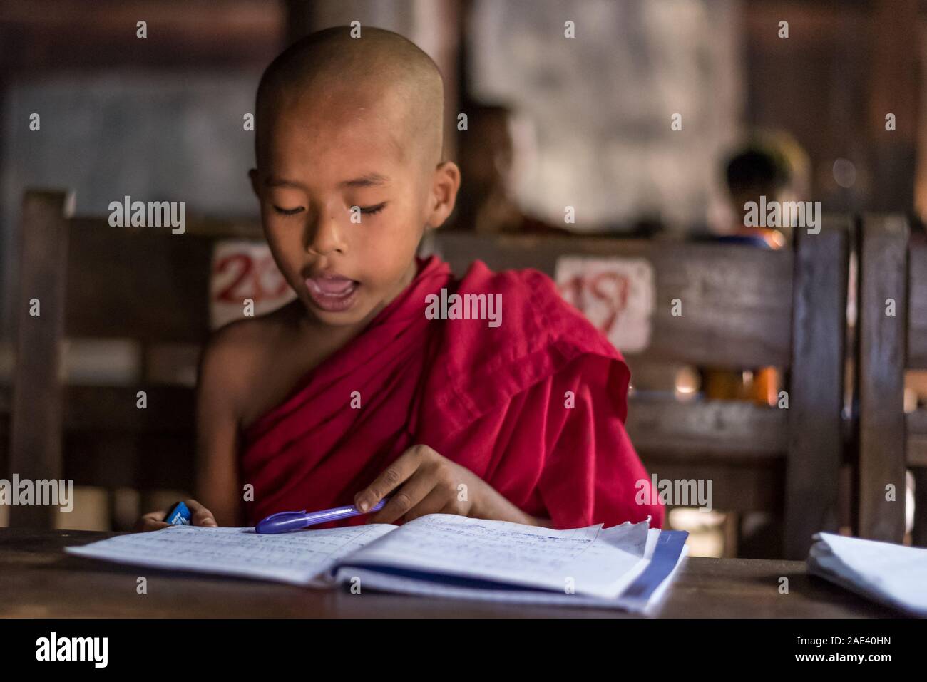 A monk studying at Bagaya Monastery in Inwa, Mandalay, Myanmar Stock Photo