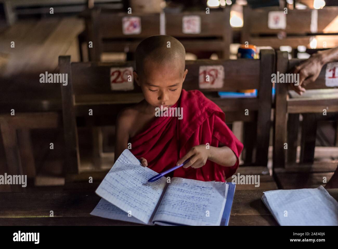 A monk studying at Bagaya Monastery in Inwa, Mandalay, Myanmar Stock Photo