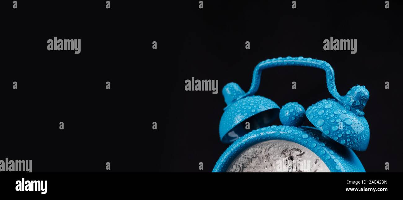 alarm clock on a balck background, water drop. Alarm clock on black