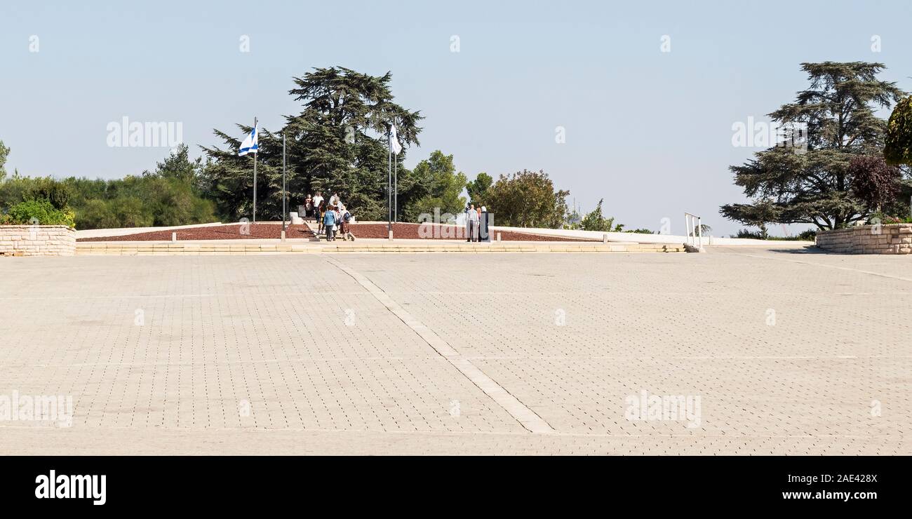 a small group of tourists visiting the grave of theodor herzl in the mount herzl national cemetery showing the open ceremonial plaza in the foreground Stock Photo