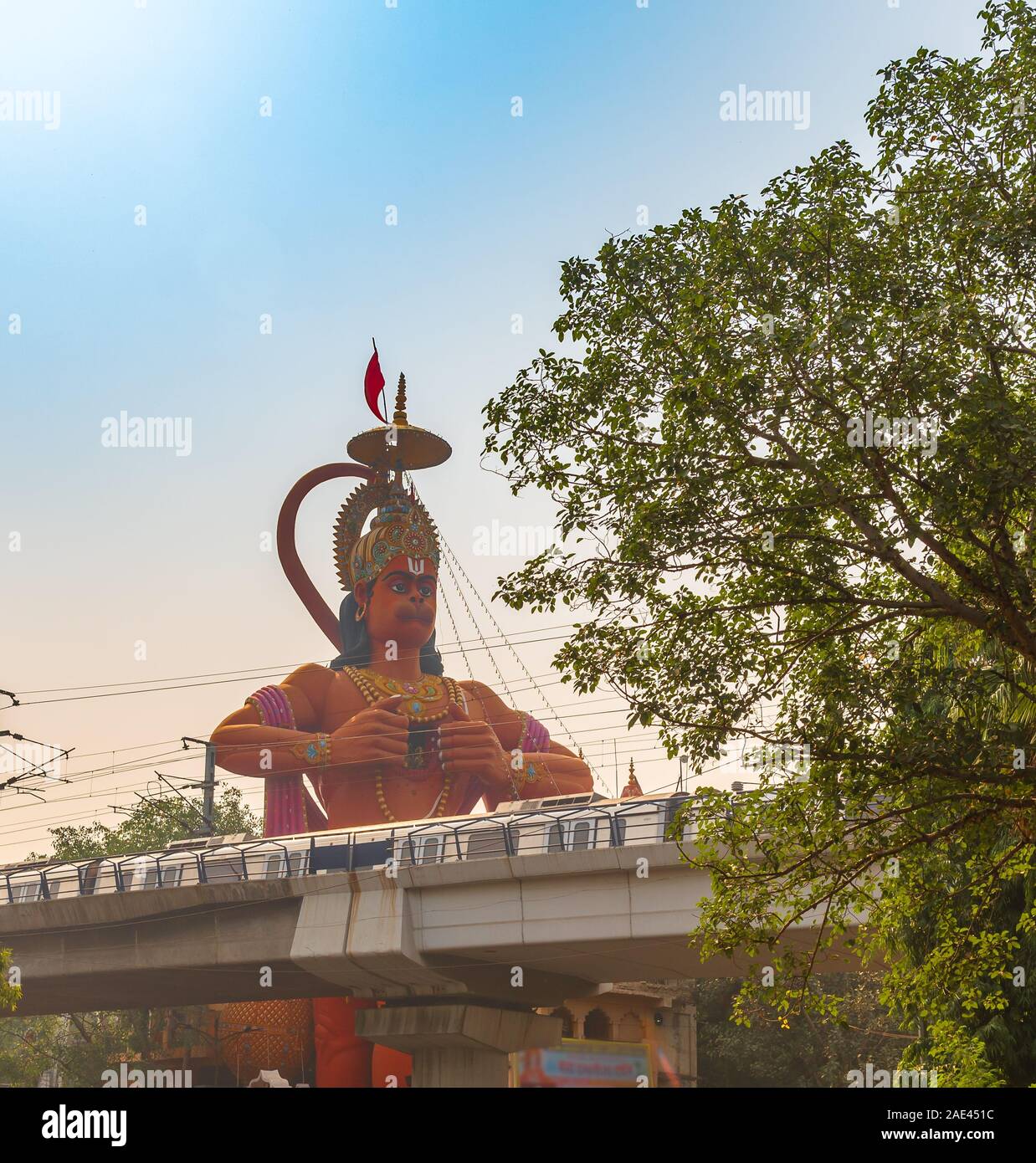 Hanuman temple near Karol Bagh Delhi with giant 108 feet statute of Lord Hanuman with view of Delhi Metro Rail service. Stock Photo
