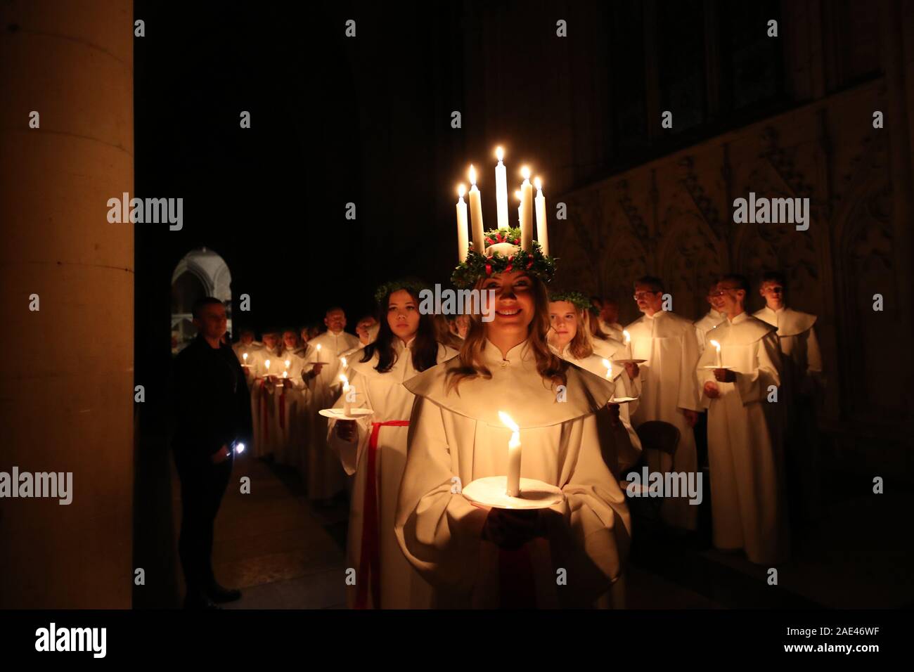 Matilda Bergstrom wearing a crown of candles symbolising St Lucy, leads a candlelit procession of the London Nordic Choir during the Sankta Lucia service at York Minster. Picture date: Friday December 6, 2019. The atmospheric Swedish service is a celebration of St Lucy, a Sicilian girl martyred for her Christian faith in the fourth century. The crown symbolises a halo, a red sash her martyrdom, and the service celebrates the bringing of light during the darkness of winter. Photo credit should read: Danny Lawson/PA Wire Stock Photo