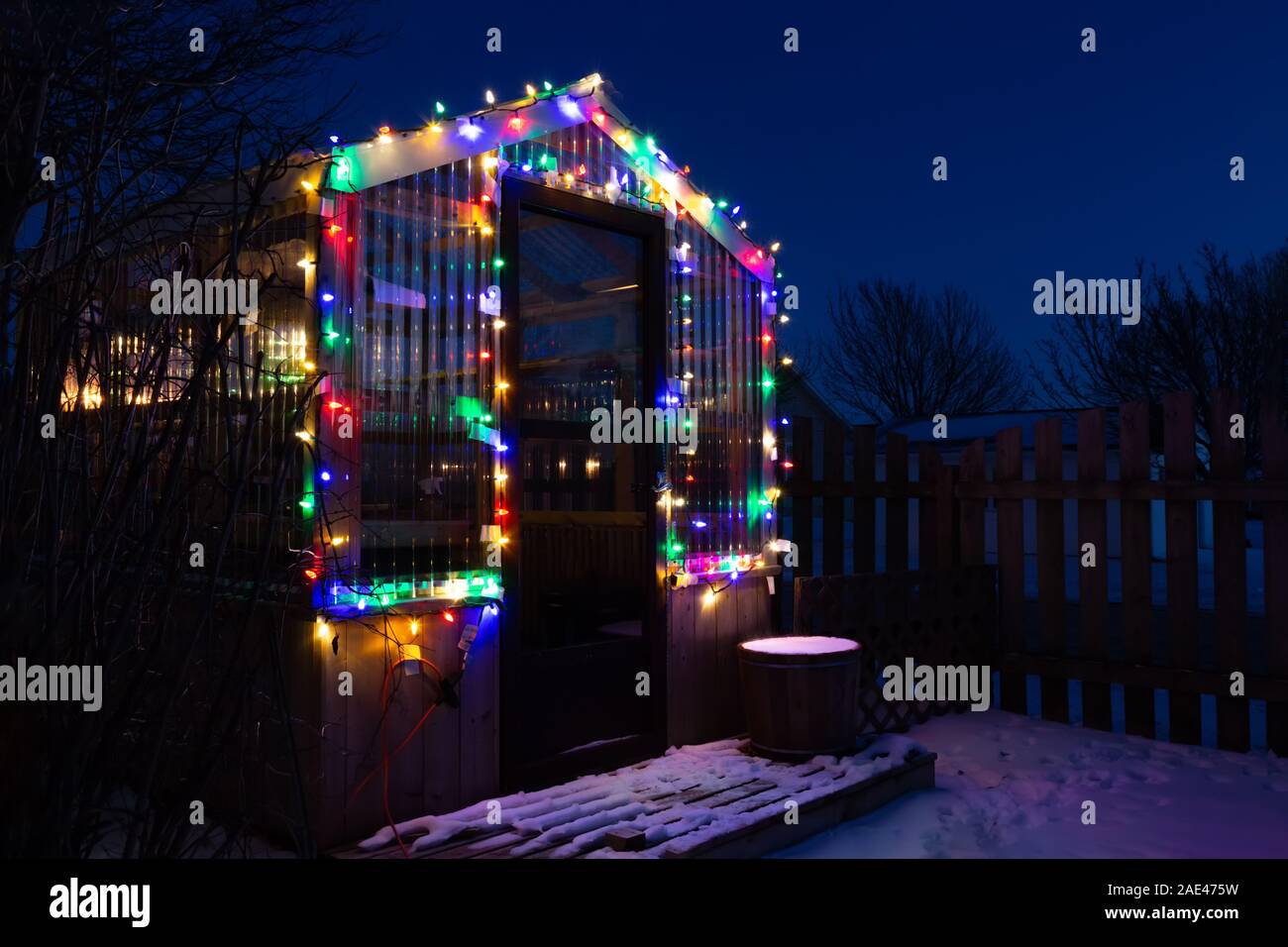 A Small Home Backyard Greenhouse Decorated With Christmas Lights And A Dusting Of Snow Stock Photo Alamy