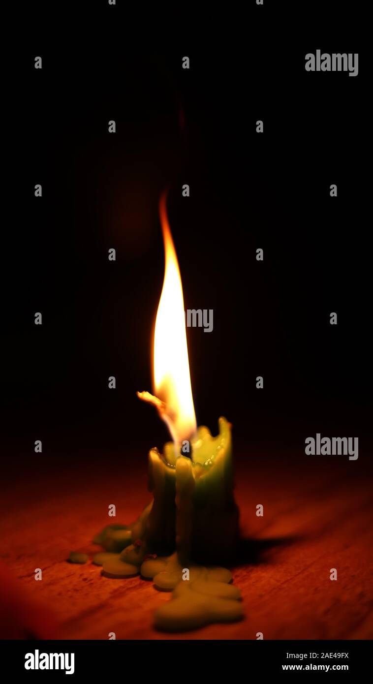 One light candle burning brightly in the black backgrounds Stock Photo