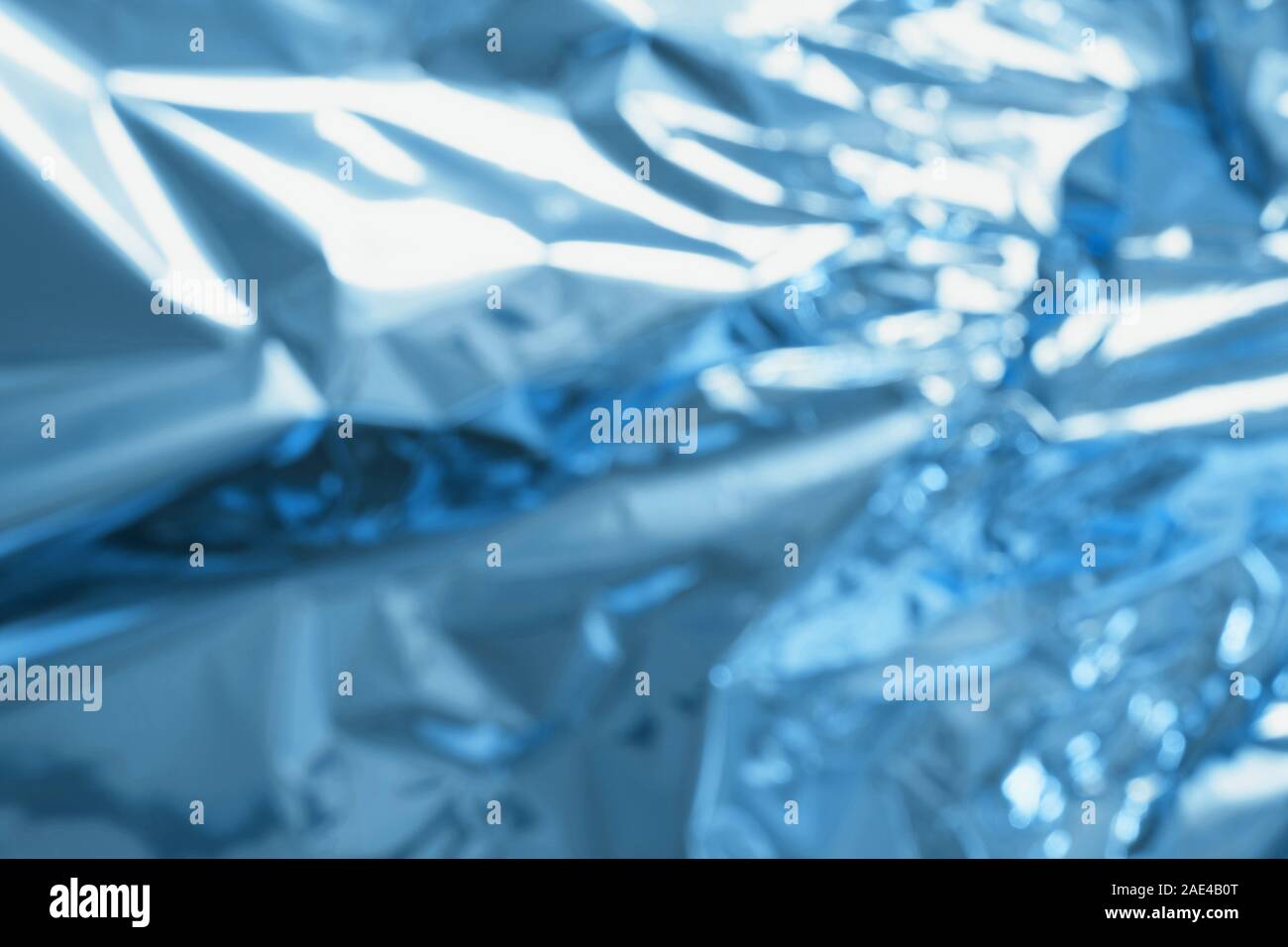 Crumpled colorful foil background. Abstract pattern with shadow. Neon classic blue color. Stock Photo