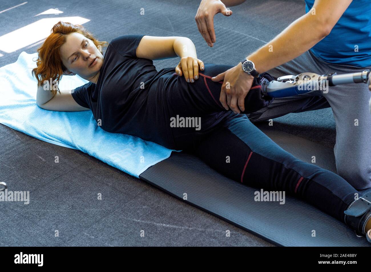 Personal trainer assisting woman with disabilities in her workout ...