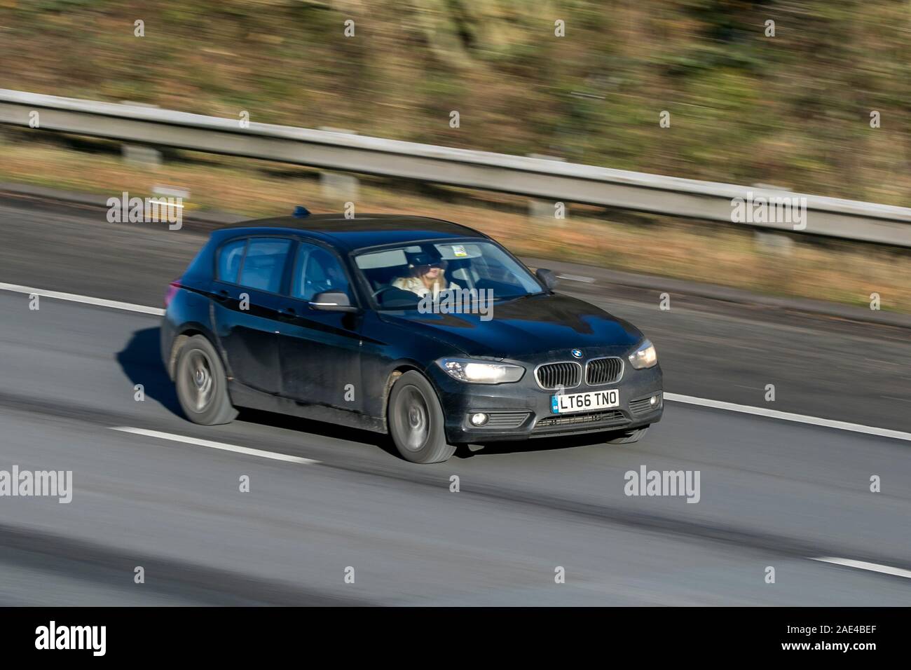 Blurred moving car BMW 116D SE AUTO traveling at speed on the M61 motorway Slow camera shutter speed vehicle movement Stock Photo