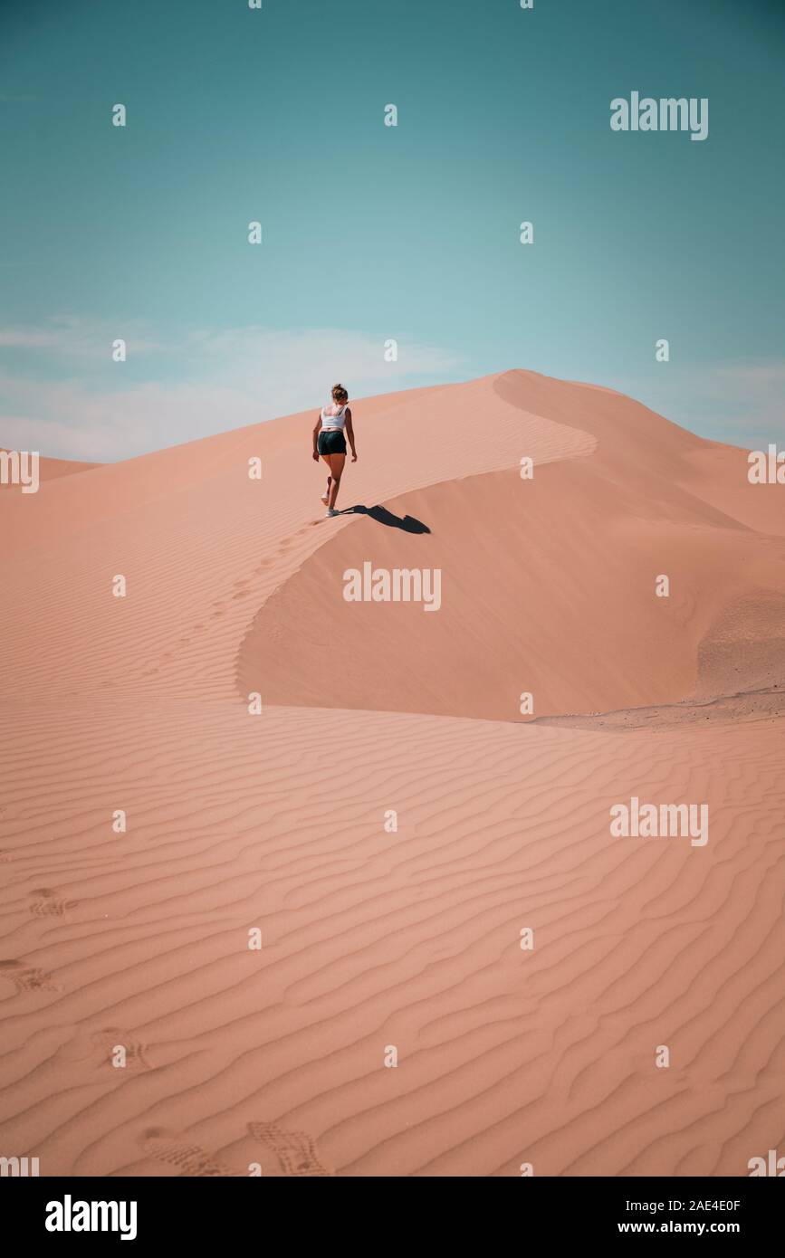 Woman climbing dune in desert hi-res stock photography and images - Alamy