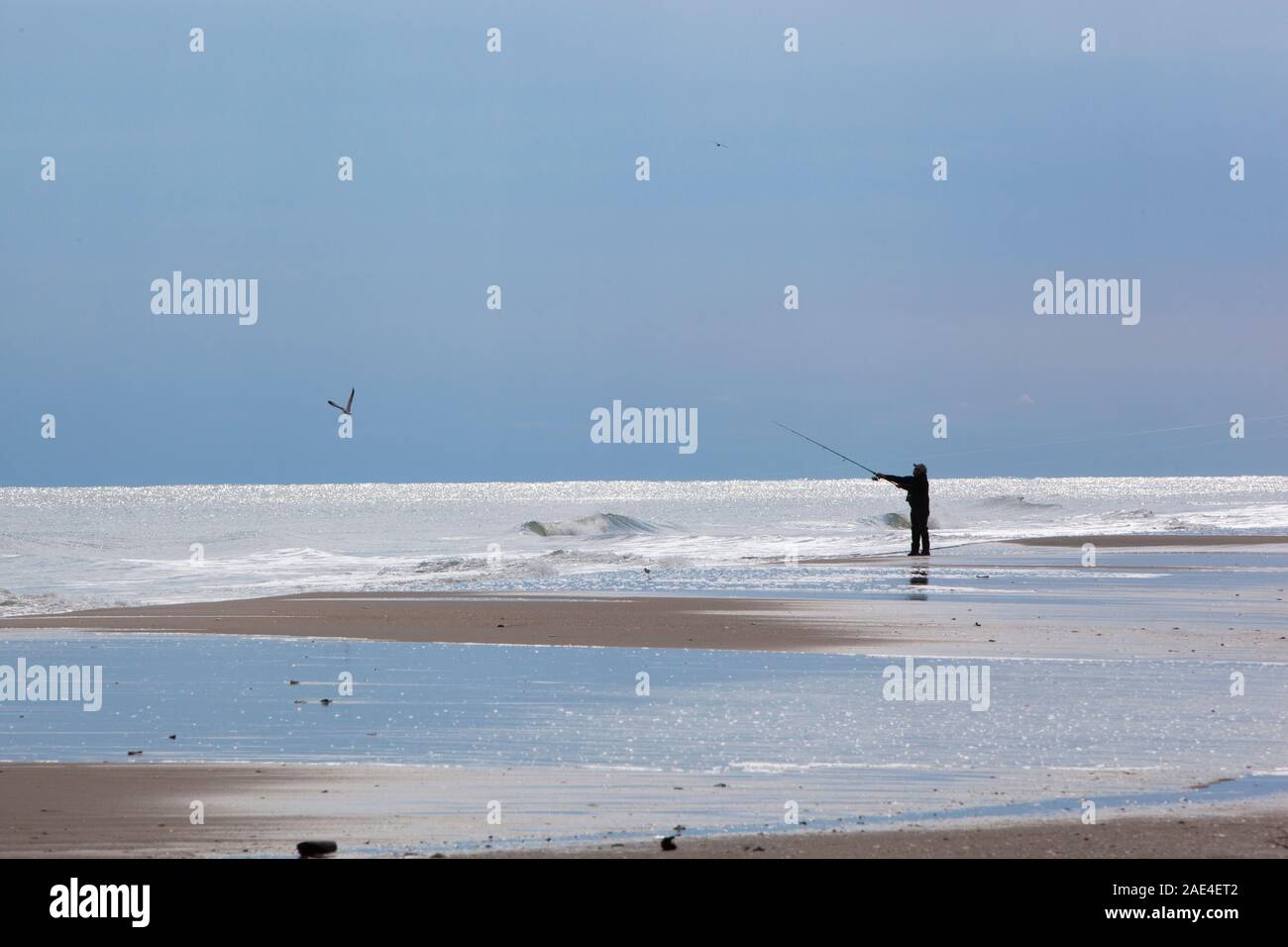 Lone surf fisherman on the shore of Assateague Island on the Atlantic coast of Maryland Stock Photo