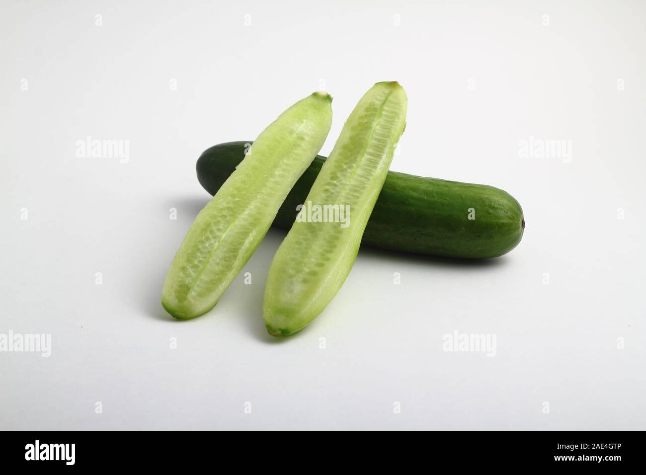 whole peeled and unpeeled fresh cucumber on white background Stock