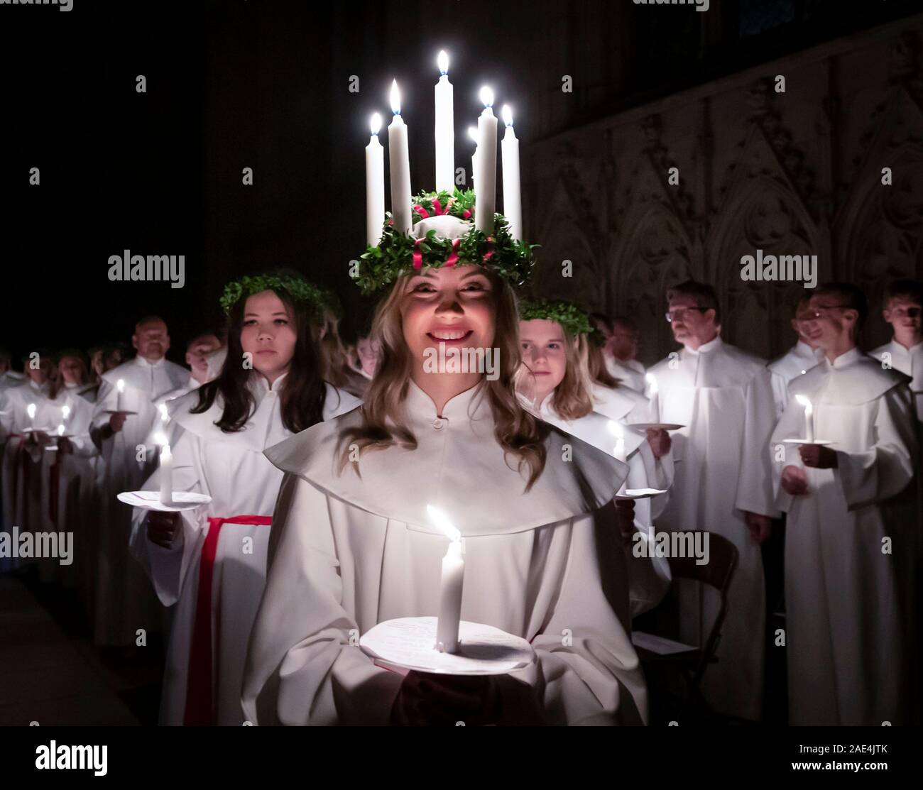 Matilda Bergstrom wearing a crown of candles symbolising St Lucy, leads a candlelit procession of the London Nordic Choir during the Sankta Lucia service at York Minster. Picture date: Friday December 6, 2019. The atmospheric Swedish service is a celebration of St Lucy, a Sicilian girl martyred for her Christian faith in the fourth century. The crown symbolises a halo, a red sash her martyrdom, and the service celebrates the bringing of light during the darkness of winter. Photo credit should read: Danny Lawson/PA Wire Stock Photo