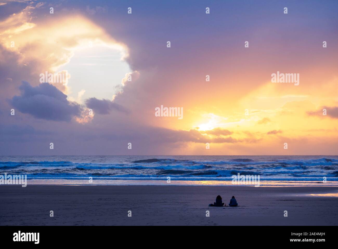 Two people on the beach watching