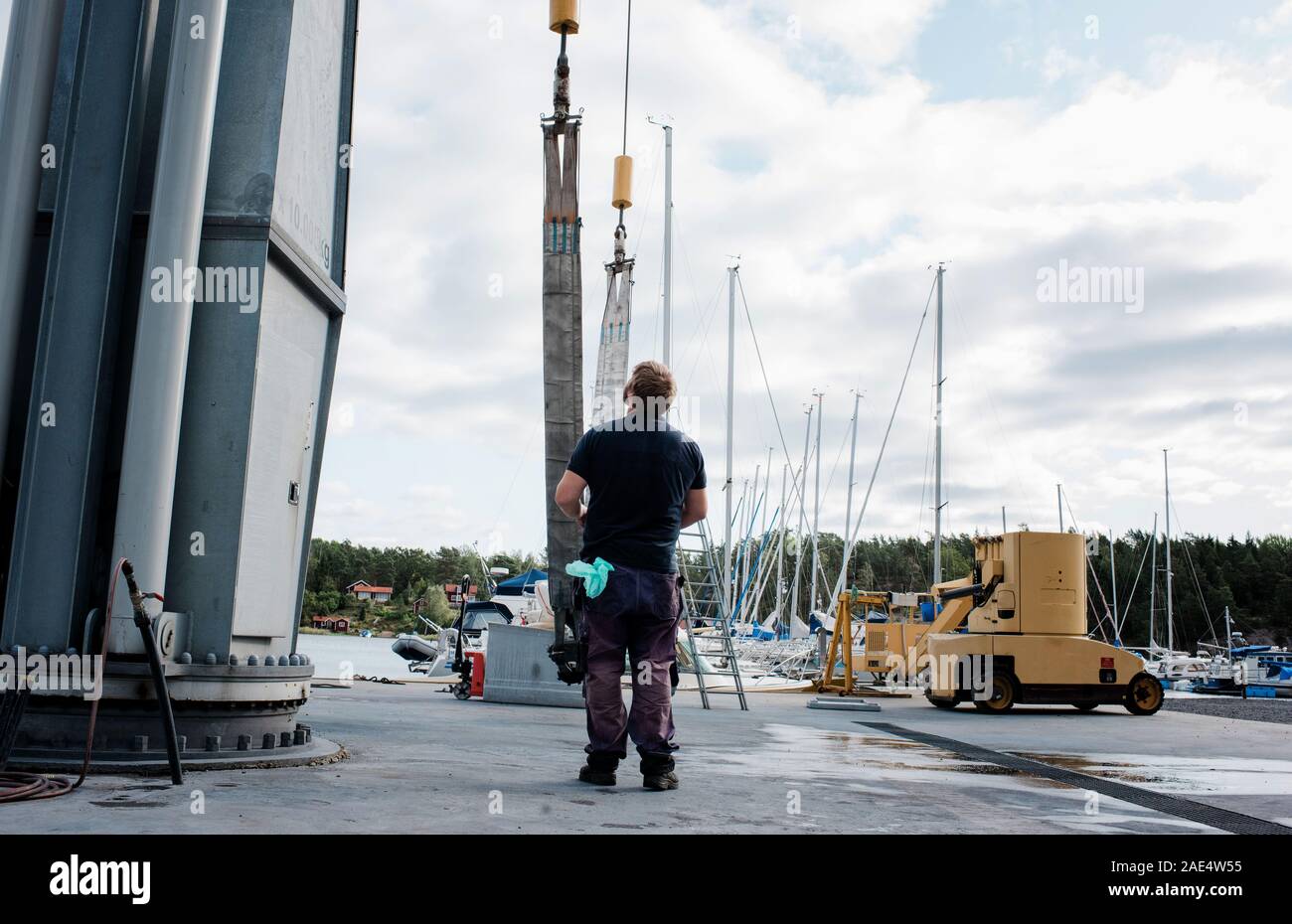 Marine engineer technician working in a boat yard moving large boats