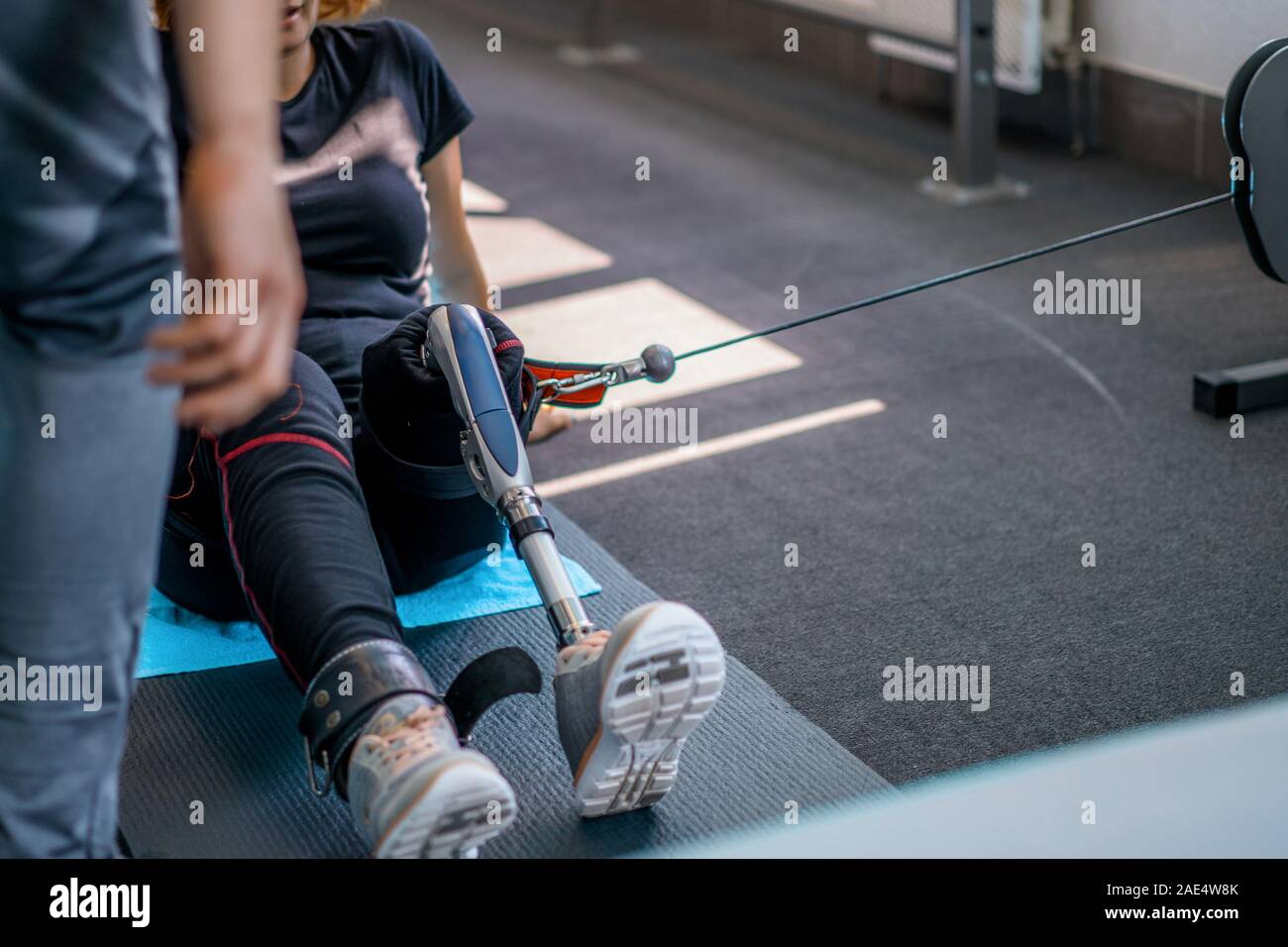 Personal trainer assisting woman with disabilities in her workout ...