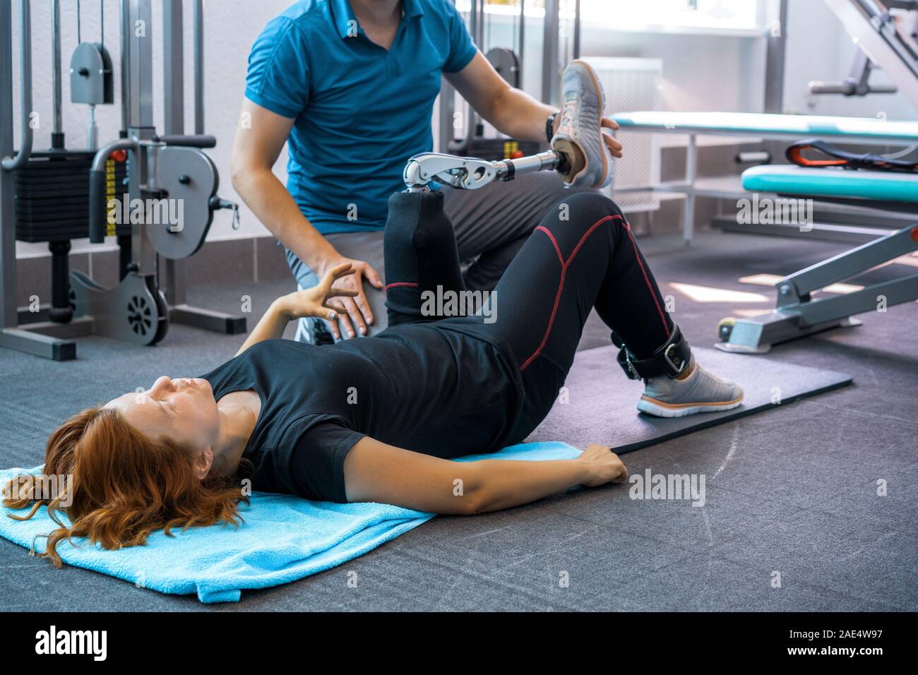 Personal trainer assisting woman with disabilities in her workout ...