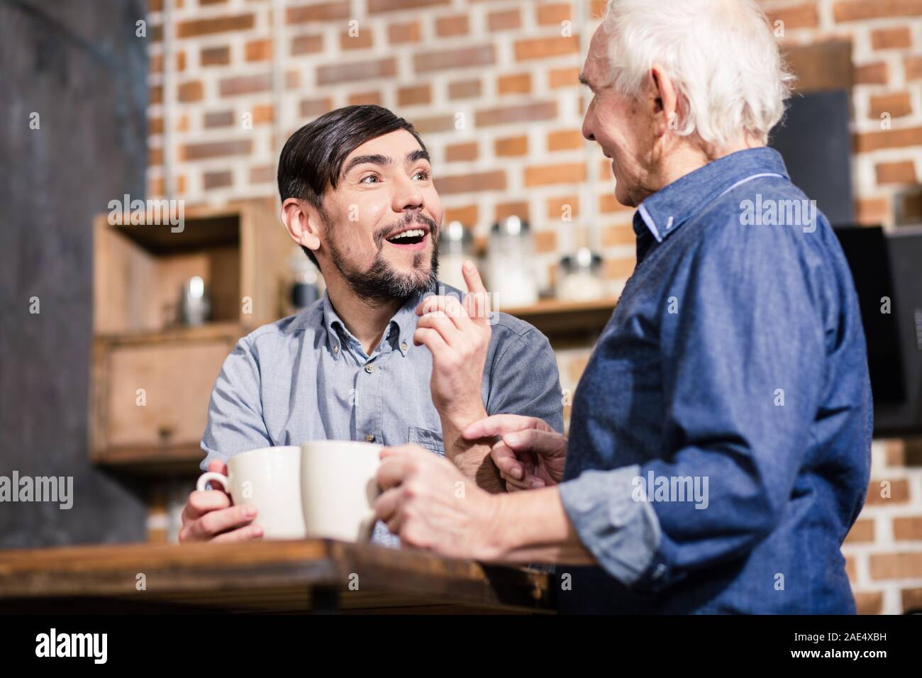 Cheerful man talking with his father in the kitchen Stock Photo