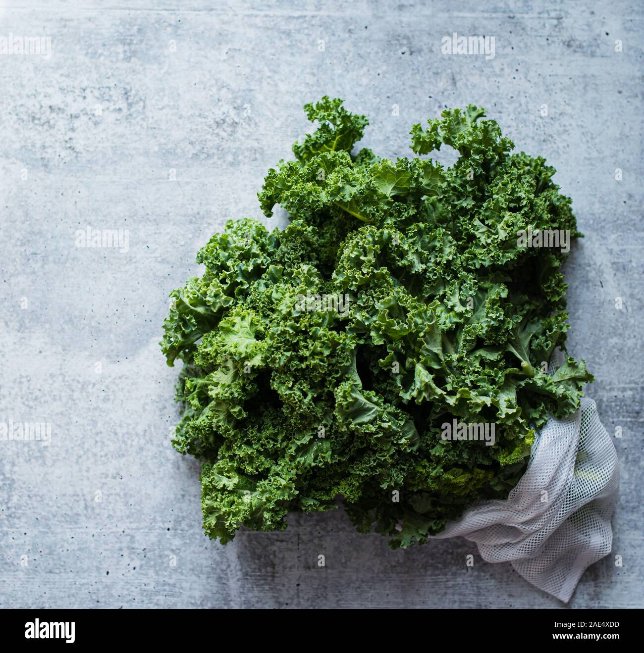 Overhead view of bunch of kale leaves against a cement counter. Stock Photo