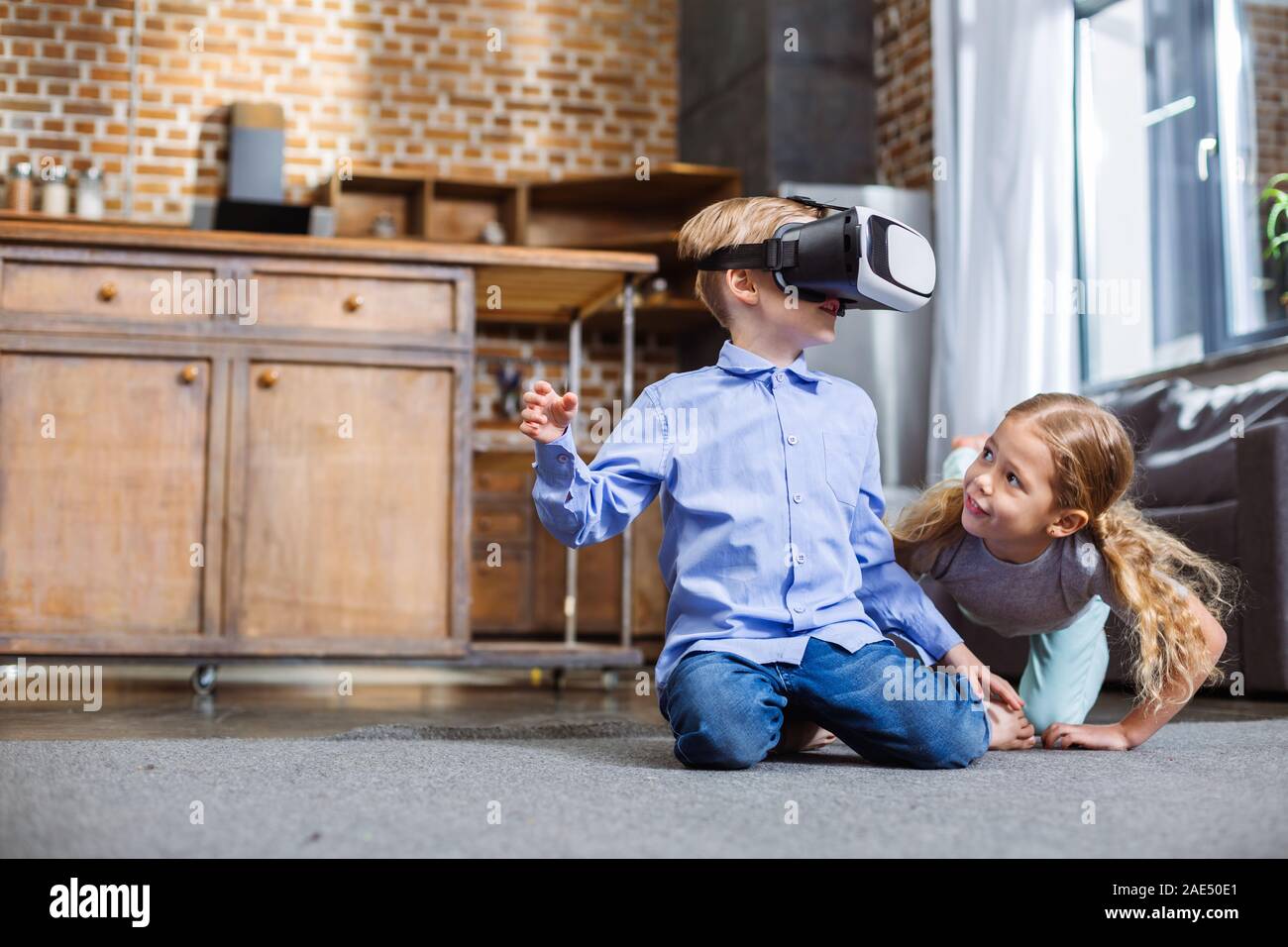 Positive siblings using VR device Stock Photo