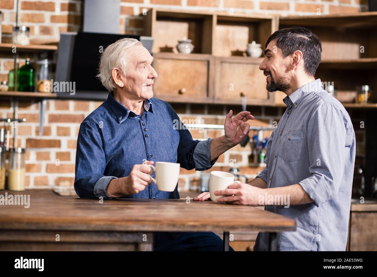 Pleasant aged man having a conversation with his son Stock Photo