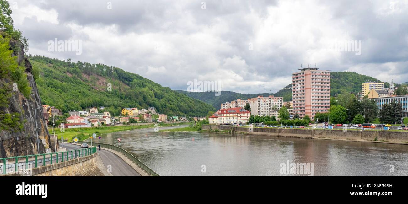 Homes and apartments on either side of the Elbe River or Labe River in Děčín Ústí nad Labem Region Czechia Czech Republic. Stock Photo