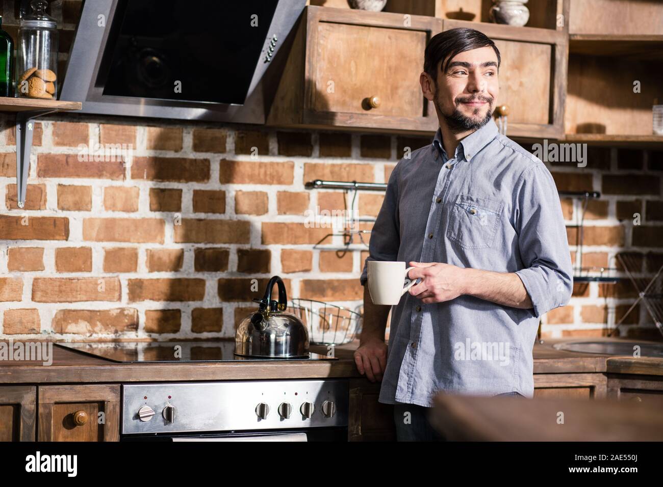 Nice bearded man drinking tea in the kitchen Stock Photo