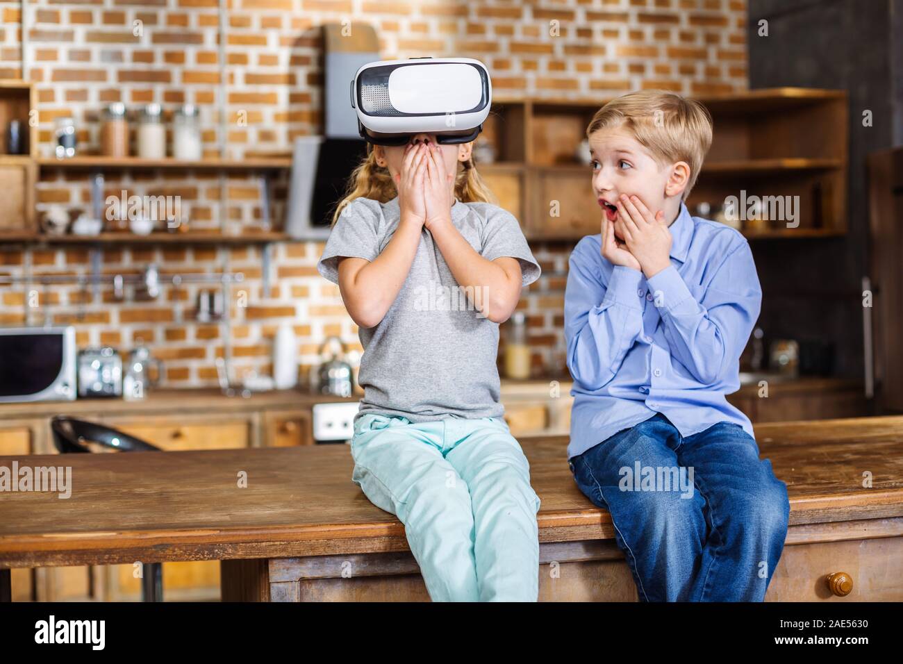 Cheerful siblings testing VR device Stock Photo