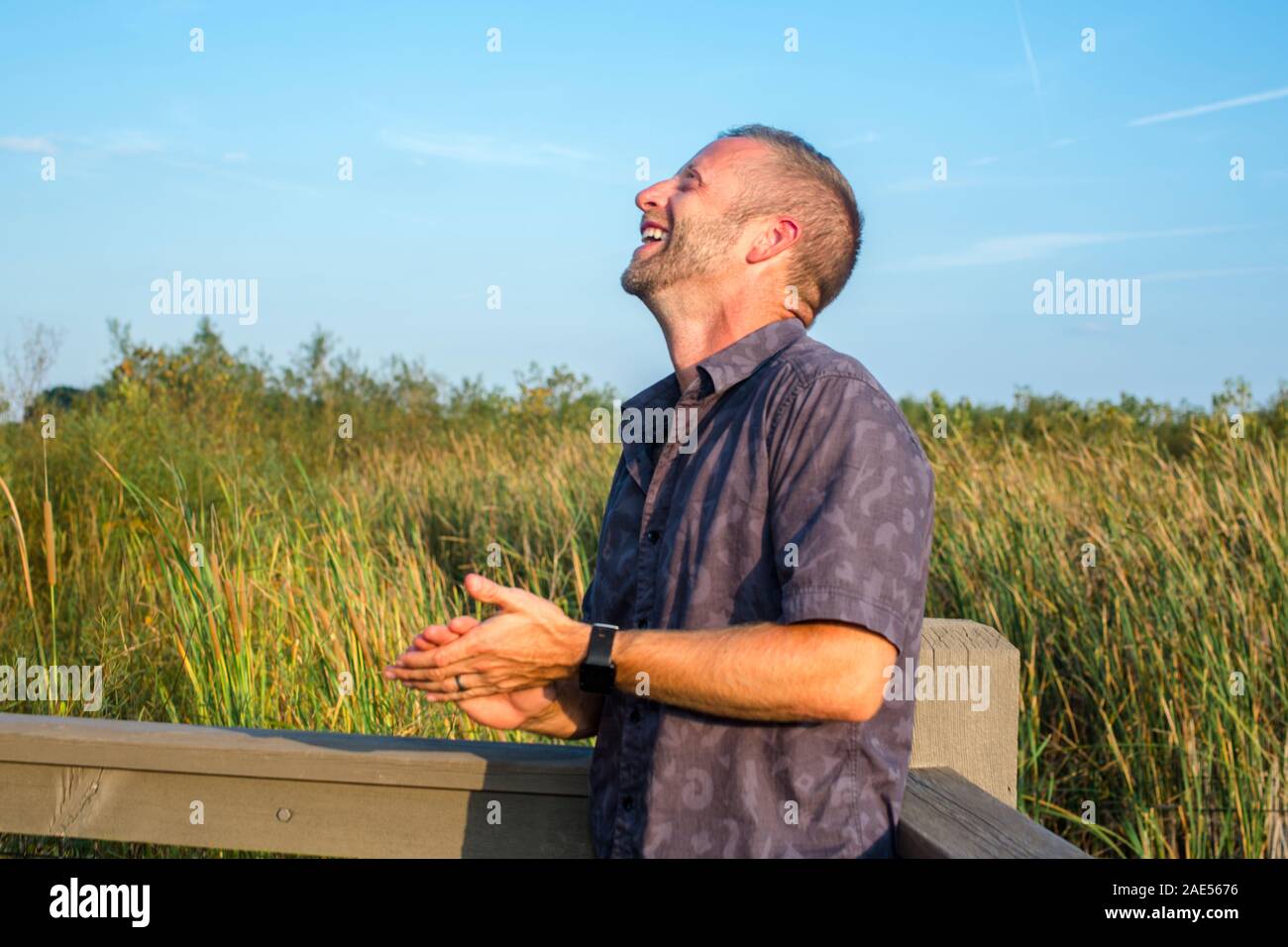 Side view of a man throwing back his head with laughter and joy Stock