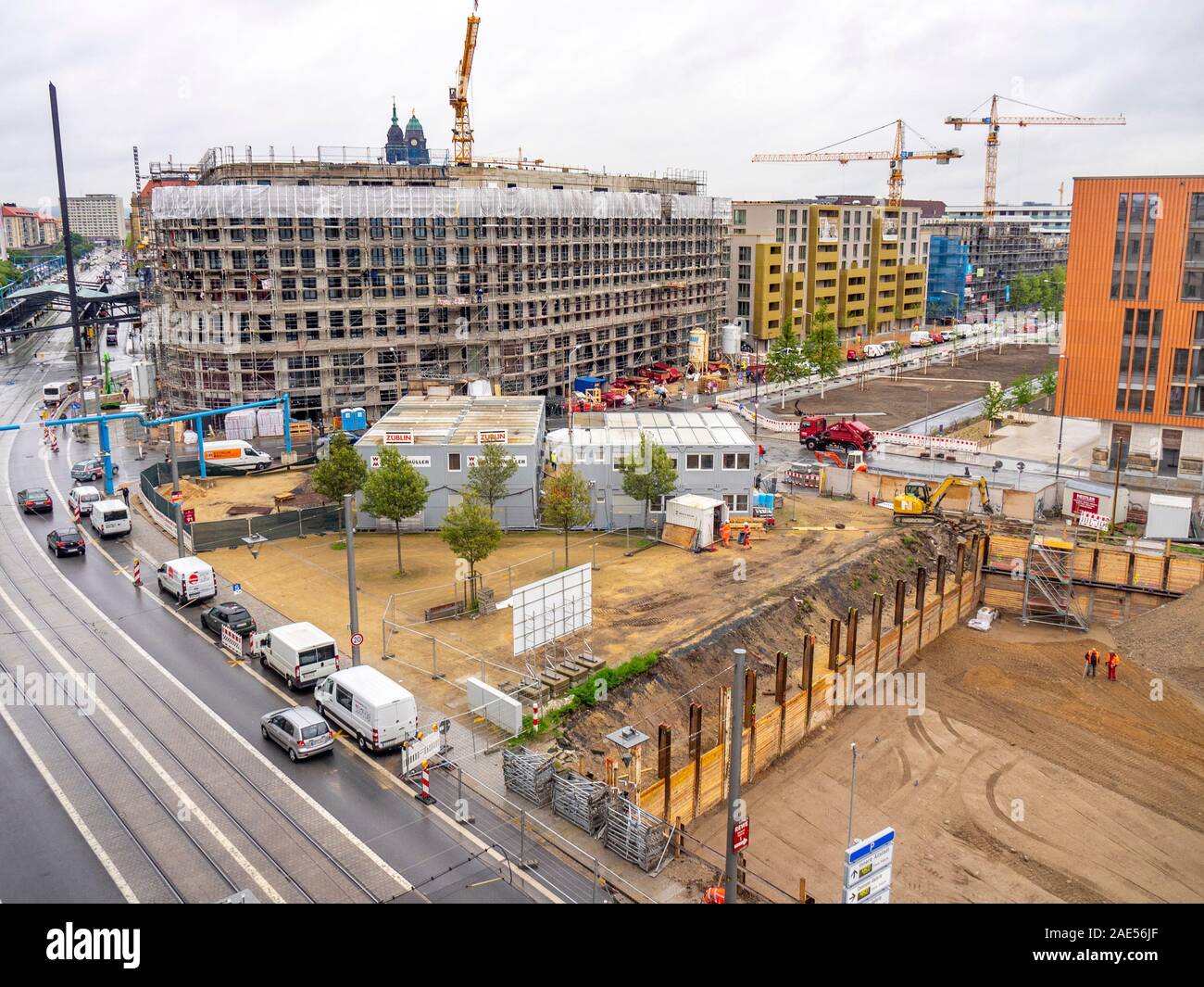 Building site for construction of apartment blocks and tower cranes lifting loads. Stock Photo