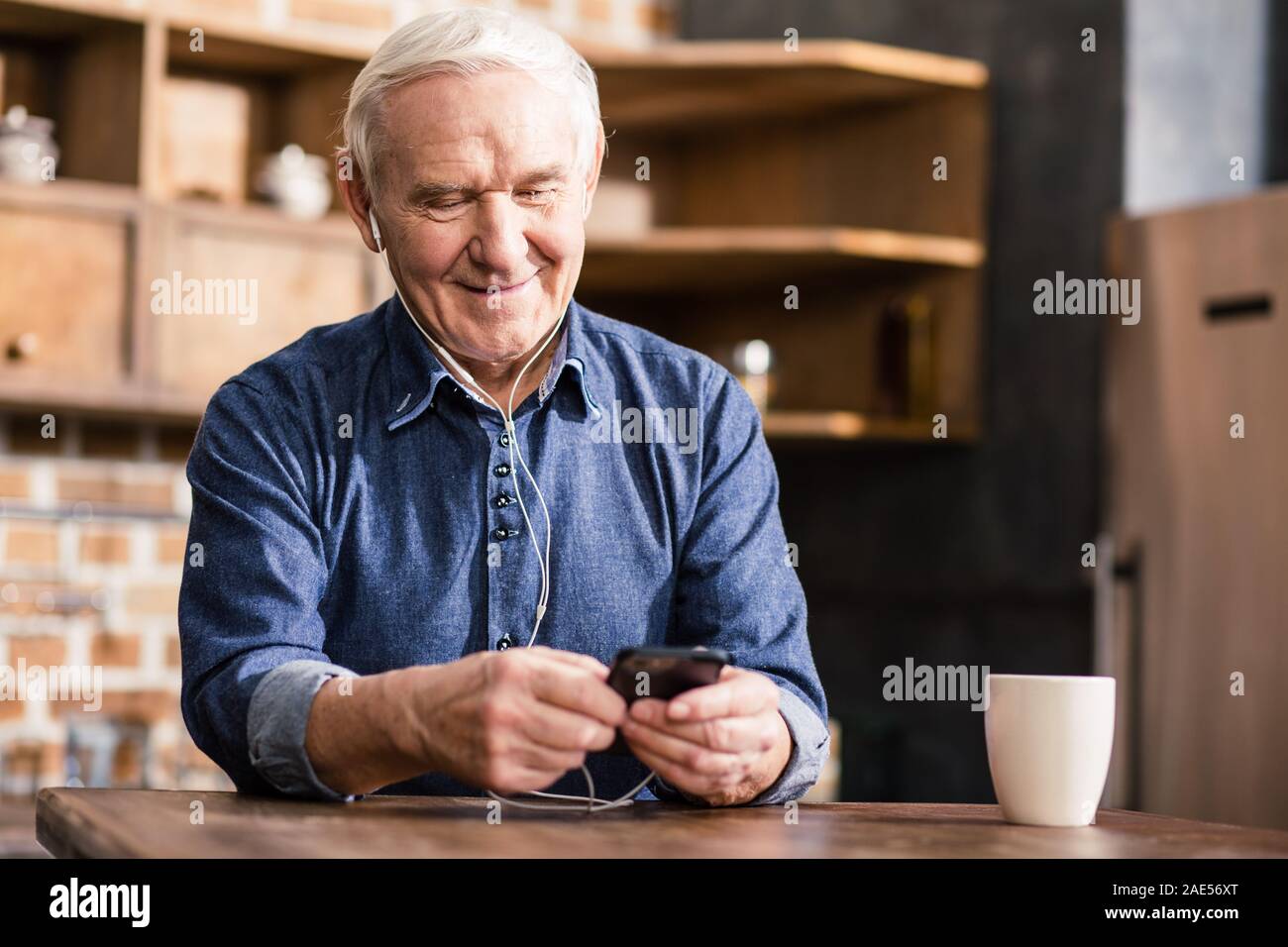 Happy aged man using his phone Stock Photo