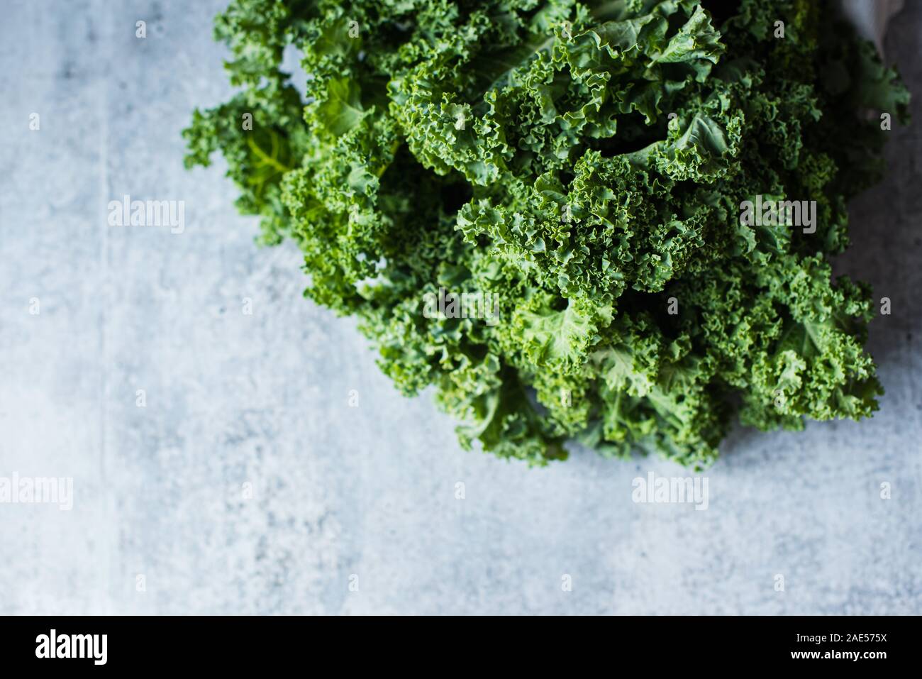 Close up top view of bunch of kale leaves against a cement counter. Stock Photo