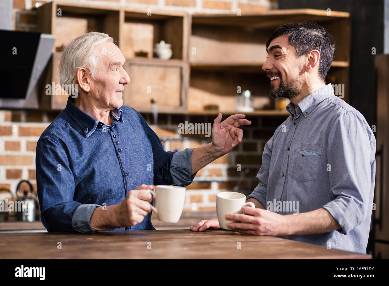 Cheerful aged man talking to his son Stock Photo