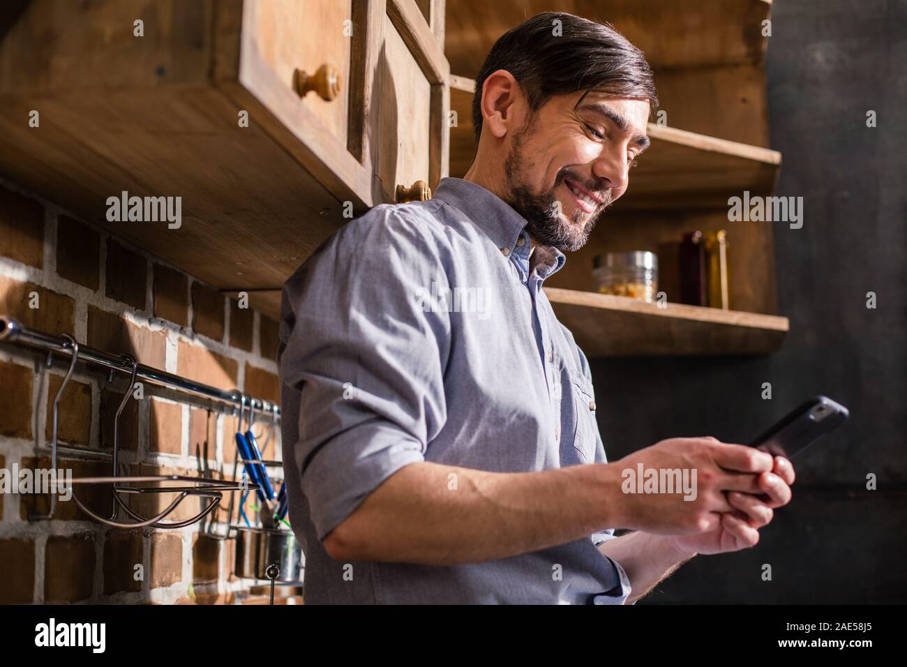 Joyful young man using his smartphone Stock Photo