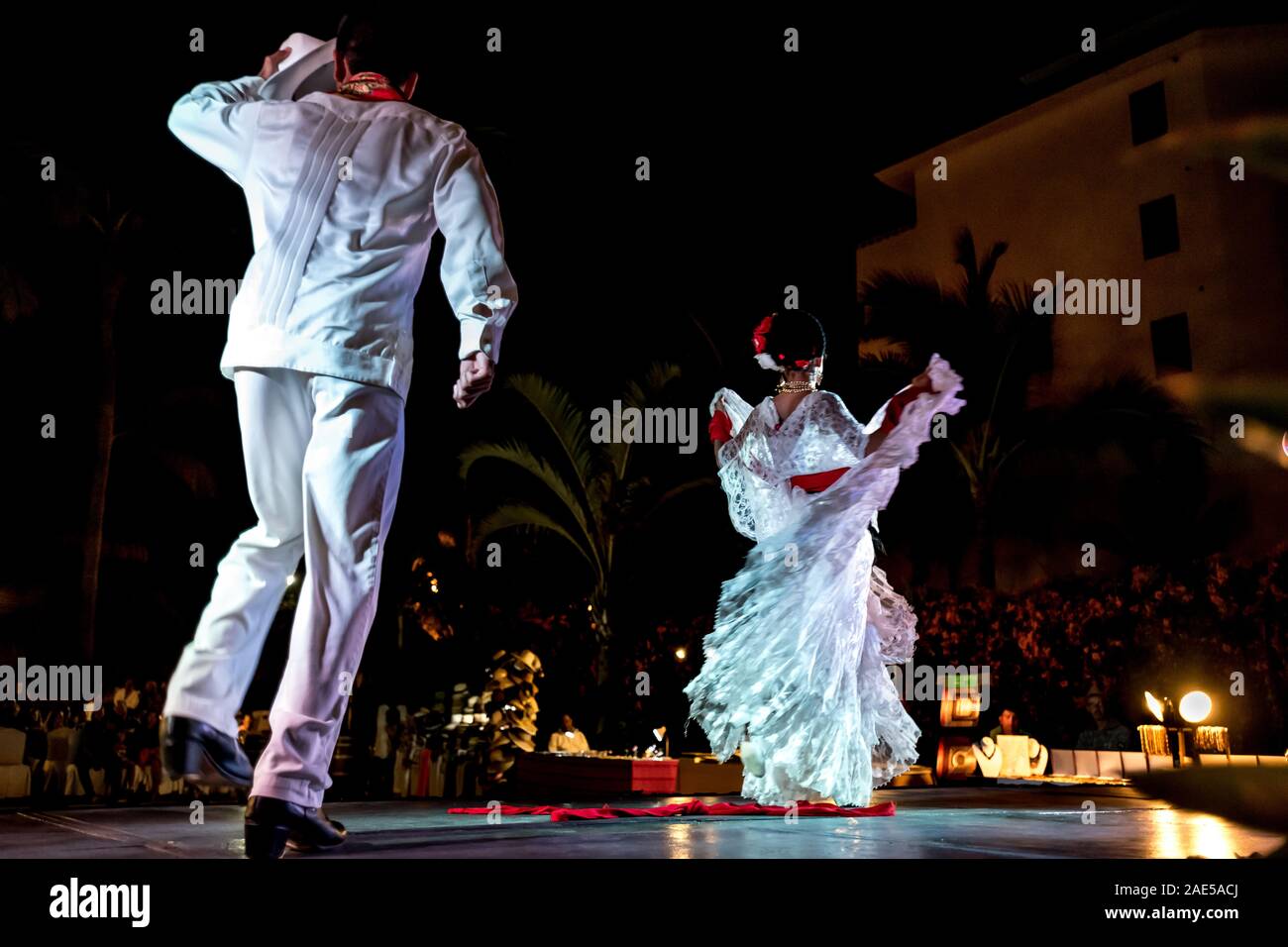 Two Mexican dancers in white costumes performing La Bamba, the traditional dance of marriage, viewed from behind in motion. Puerto Vallarta, Mexico. Stock Photo
