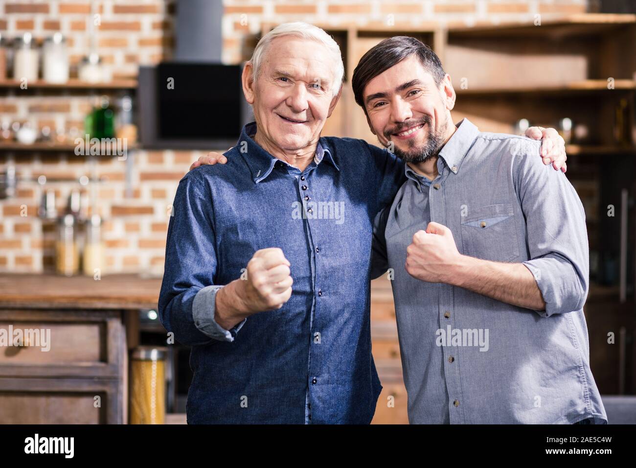 Positive elderly man embracing with his son Stock Photo