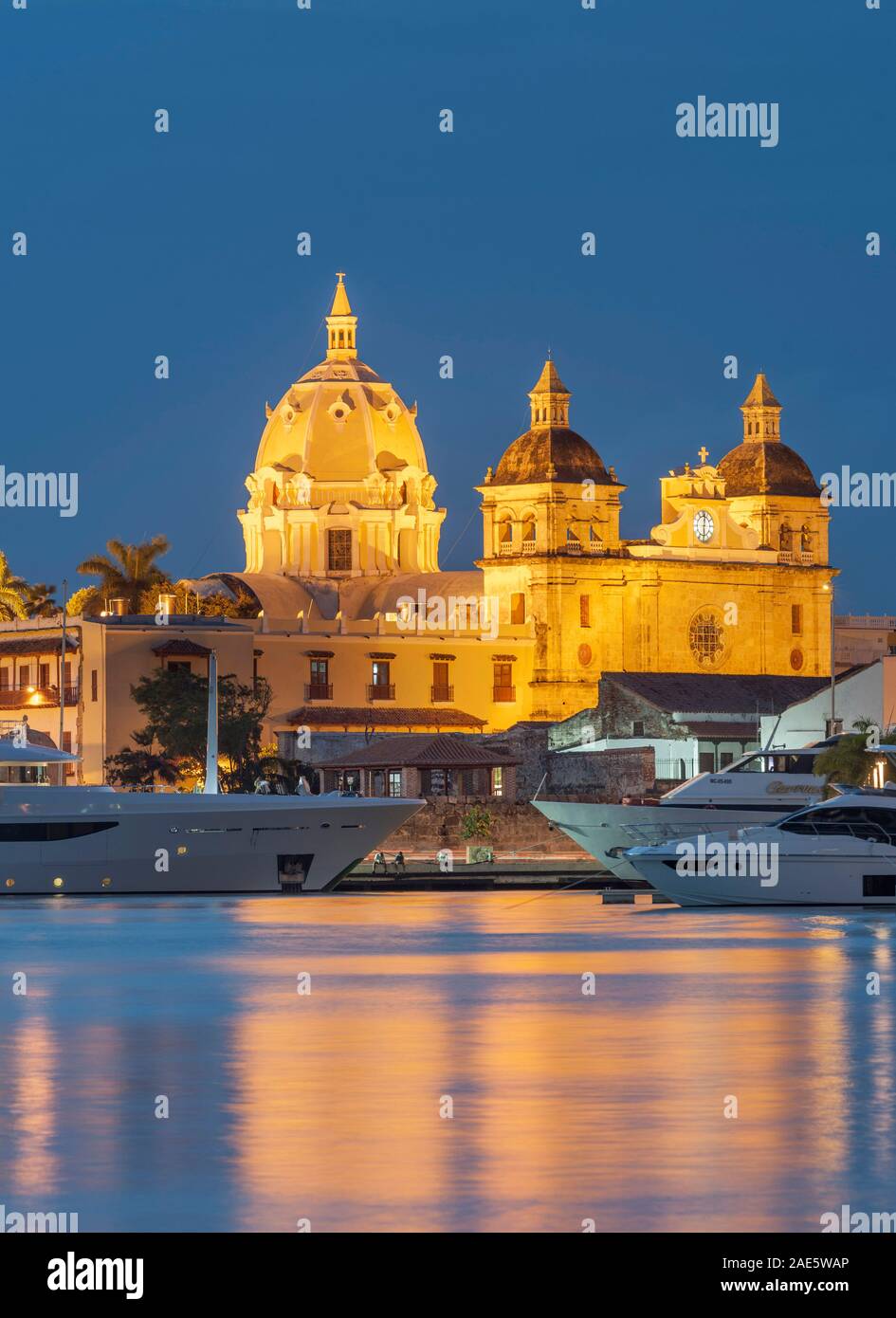 Dusk view of boats moored alongside the historic buildings of the walled old city of Cartagena in Colombia. Stock Photo