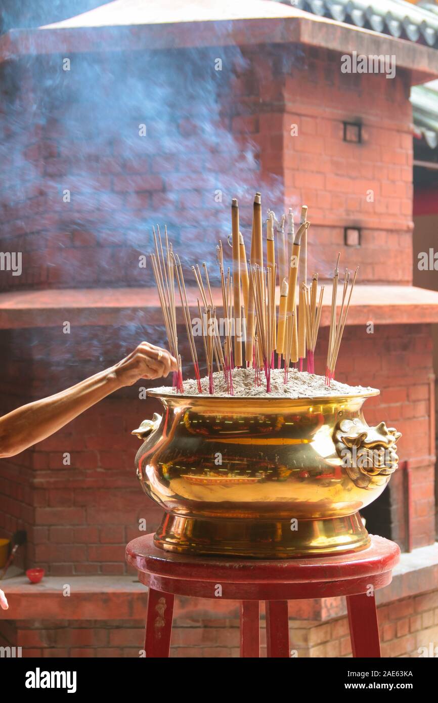Joss stick burning in incense furnace at a chinese temple. Concept of chinese offering ritual