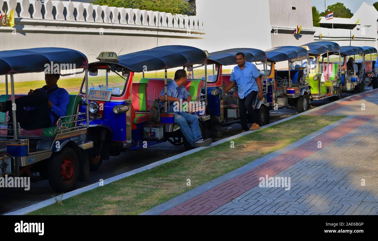Bangkok, Thailand - December 2, 2019 : Row of three-wheeled motor vehicle or tuk tuk parking along roadside of the street in front of  Wat Pho Stock Photo
