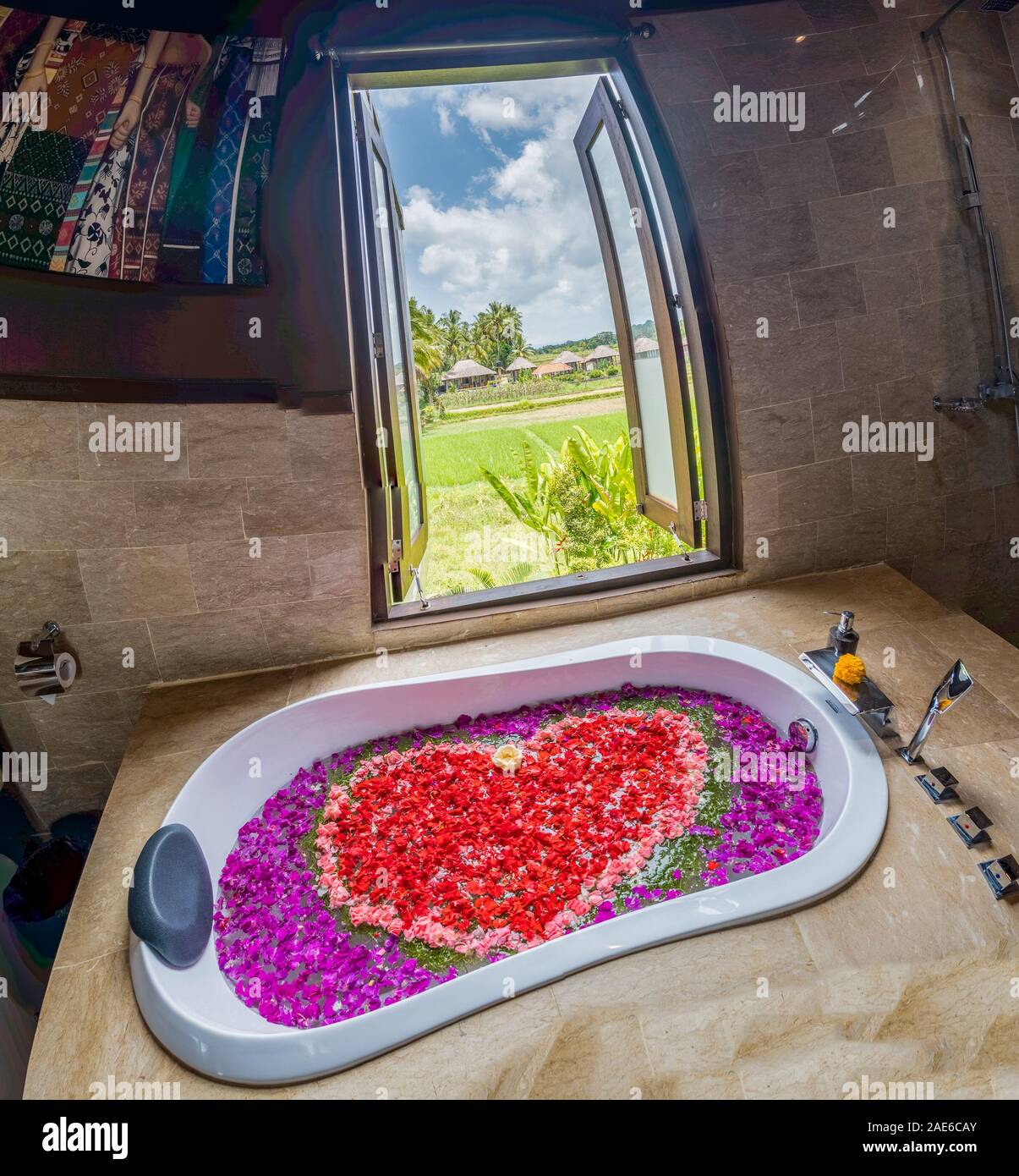 Bathtub filled with various flowers in a heart shape with window open